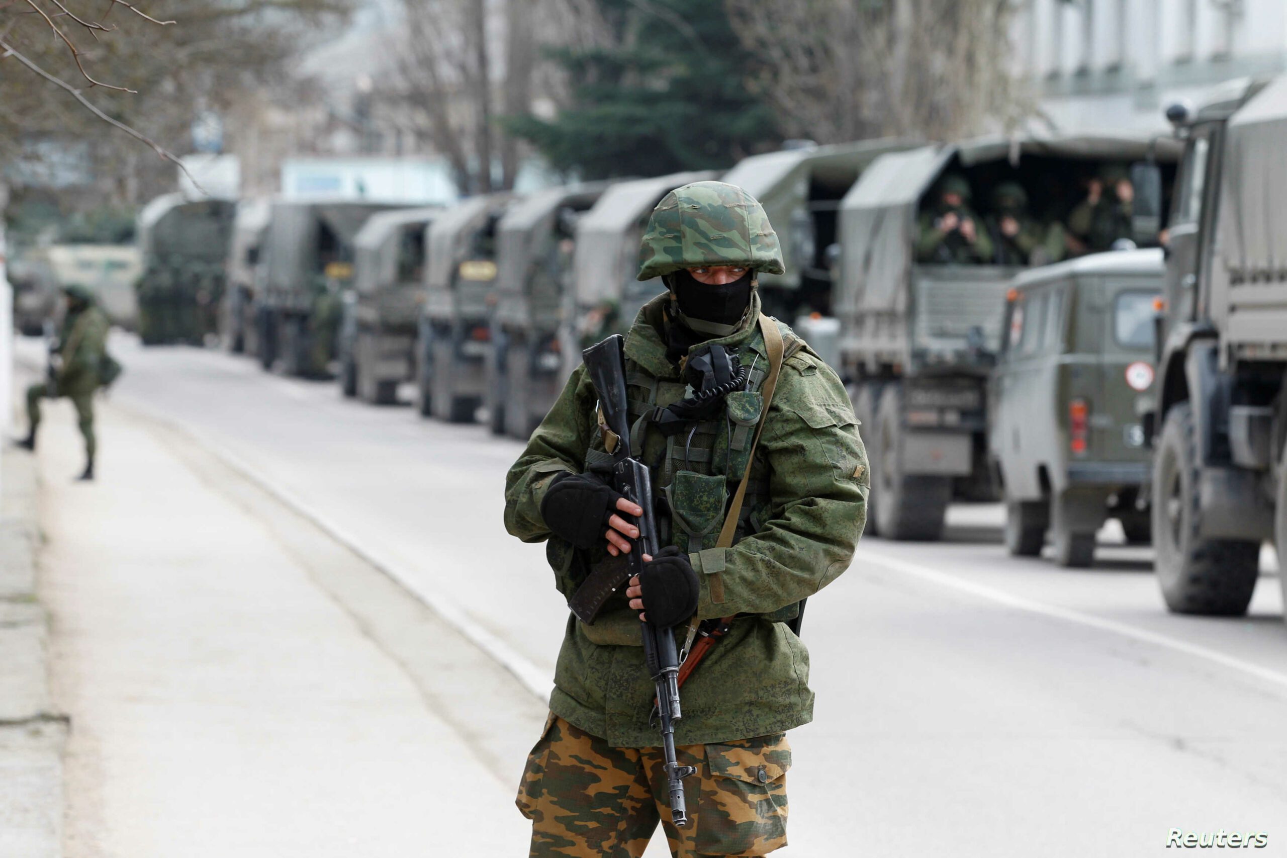 FILE PHOTO: Armed servicemen wait in Russian army vehicles outside a Ukranian border guard post in the Crimean town of Balaclava روسيا انهت مناوراتها العسكرية وسحبت جزءا من قواتها في القرم