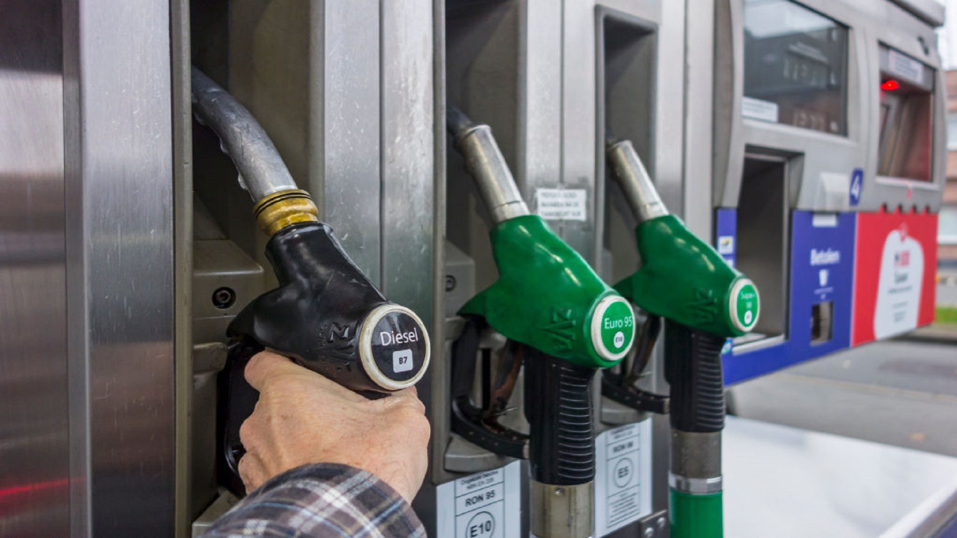 Man selecting diesel fuel pump nozzle at gas station for refueling his car in Europe. كيف برر البركس ارتفاع سعر البنزين؟