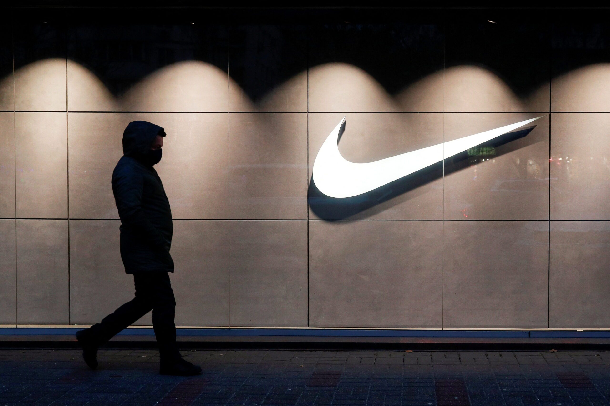 FILE PHOTO: A man wearing a protective face mask walks past a Nike brand store central in Kyiv شركة Nike انسحبت من السوق الروسية