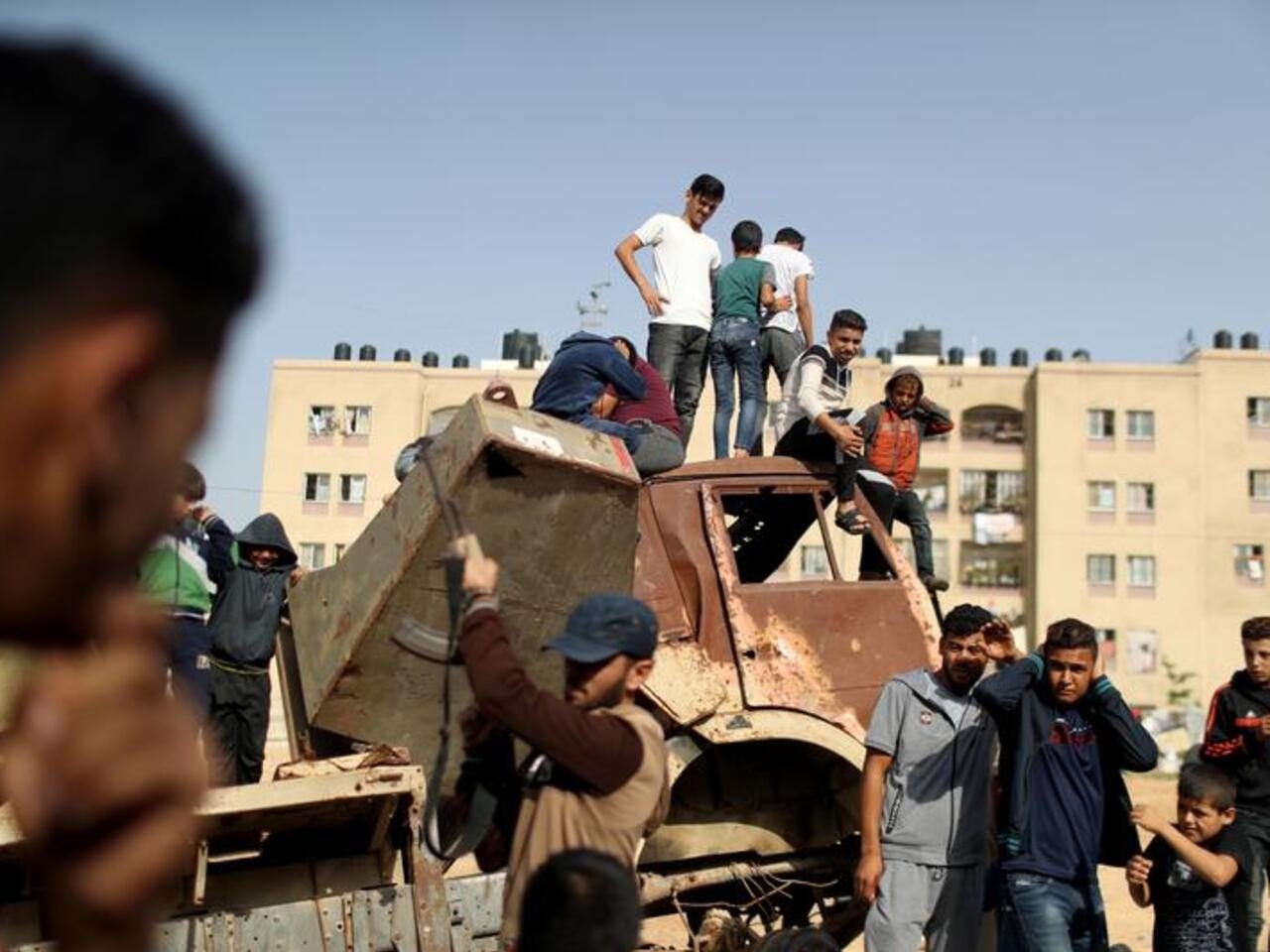 Palestinians react as a gunman fires a weapon in the air during the funeral of Islamic Jihad militant Abdullah al-Belbasi, in the northern Gaza Strip