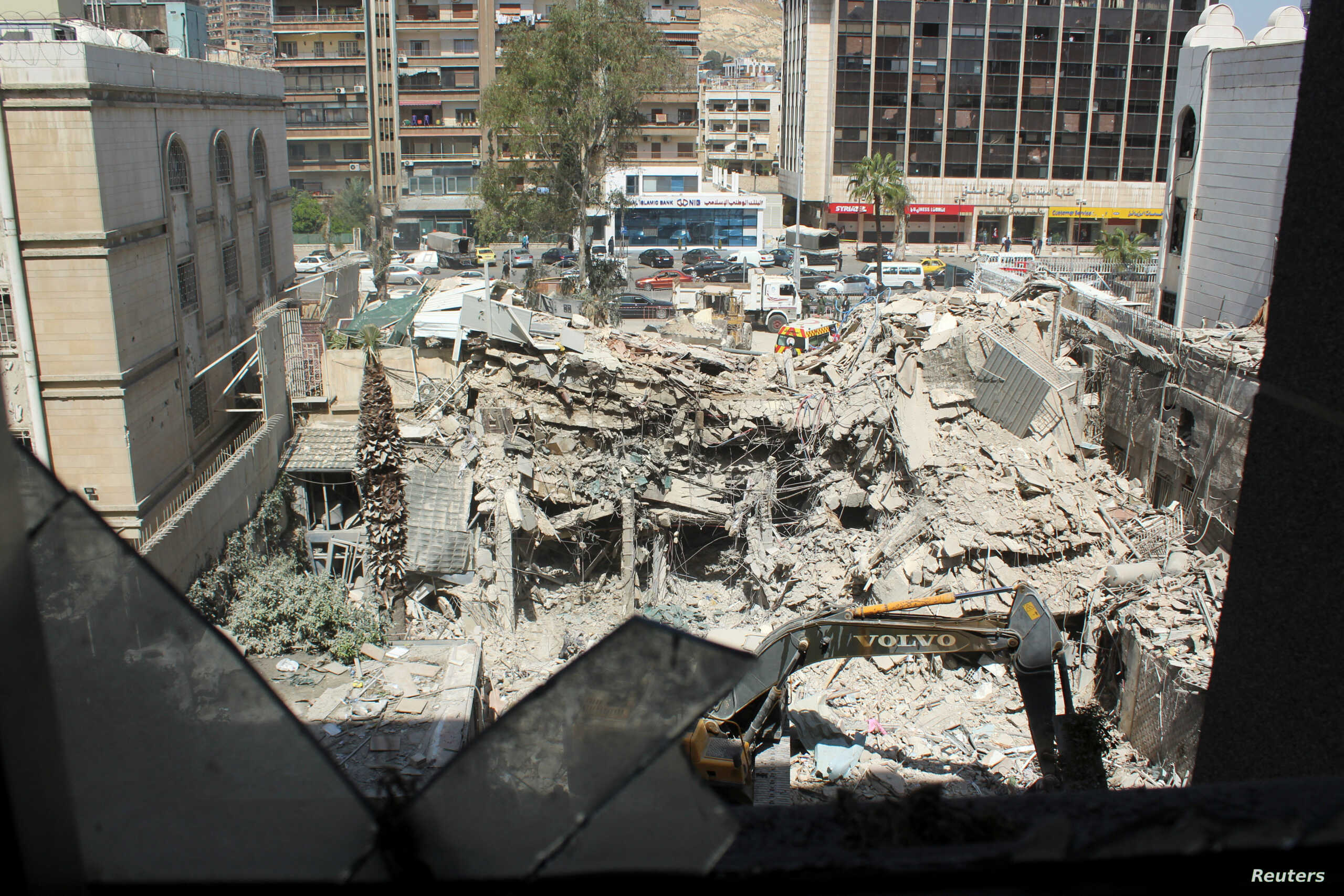 An excavator clears rubble after a suspected Israeli strike on Iran’s consulate, in Damascus خاص – هل ضرب إيران هو جرس إنذار إلى الحزب؟