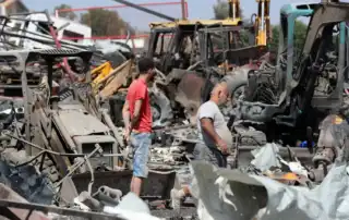 لبنانيون يتفقدون موقعاً استهدفته غارة إسرائيلية في بلدة أنصارية بجنوب لبنان