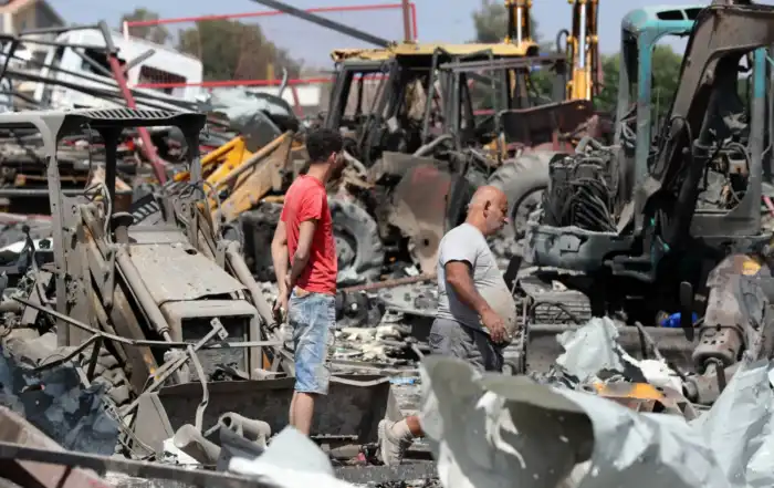 لبنانيون يتفقدون موقعاً استهدفته غارة إسرائيلية في بلدة أنصارية بجنوب لبنان